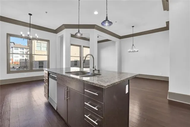 a kitchen with stainless steel appliances granite countertop a stove a sink and a wooden floor