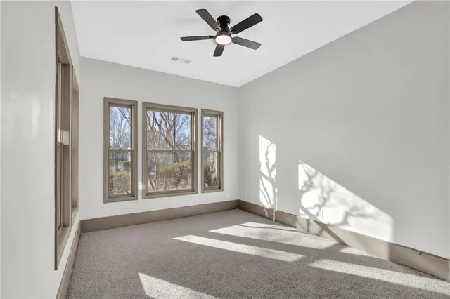 a view of a livingroom with a ceiling fan and window