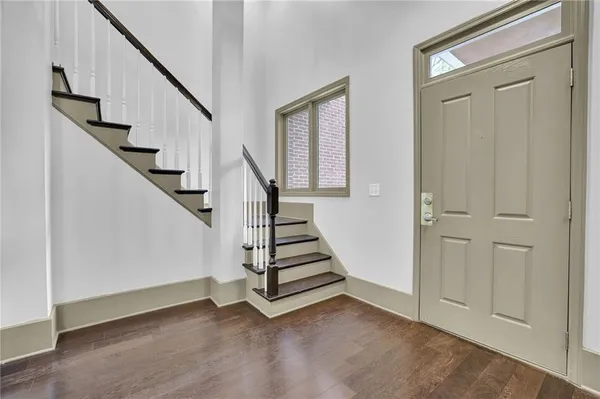 a view of a hallway with staircase and white walls