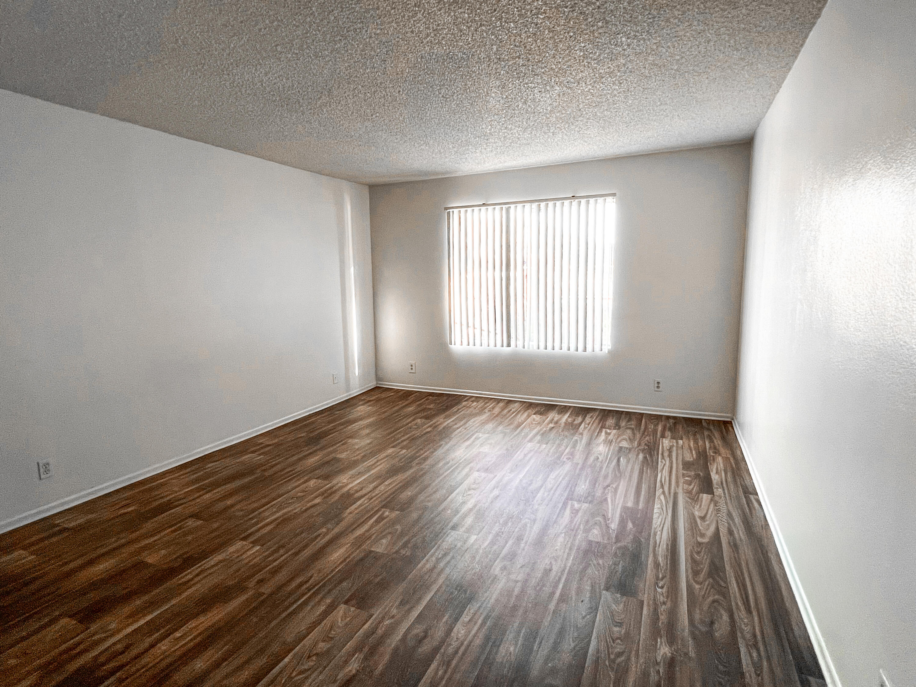 1400 East Palm Canyon Drive, Unit 109 Palm Springs, CA 92264 - Photo 8 of 14 an empty room with wooden floor and windows