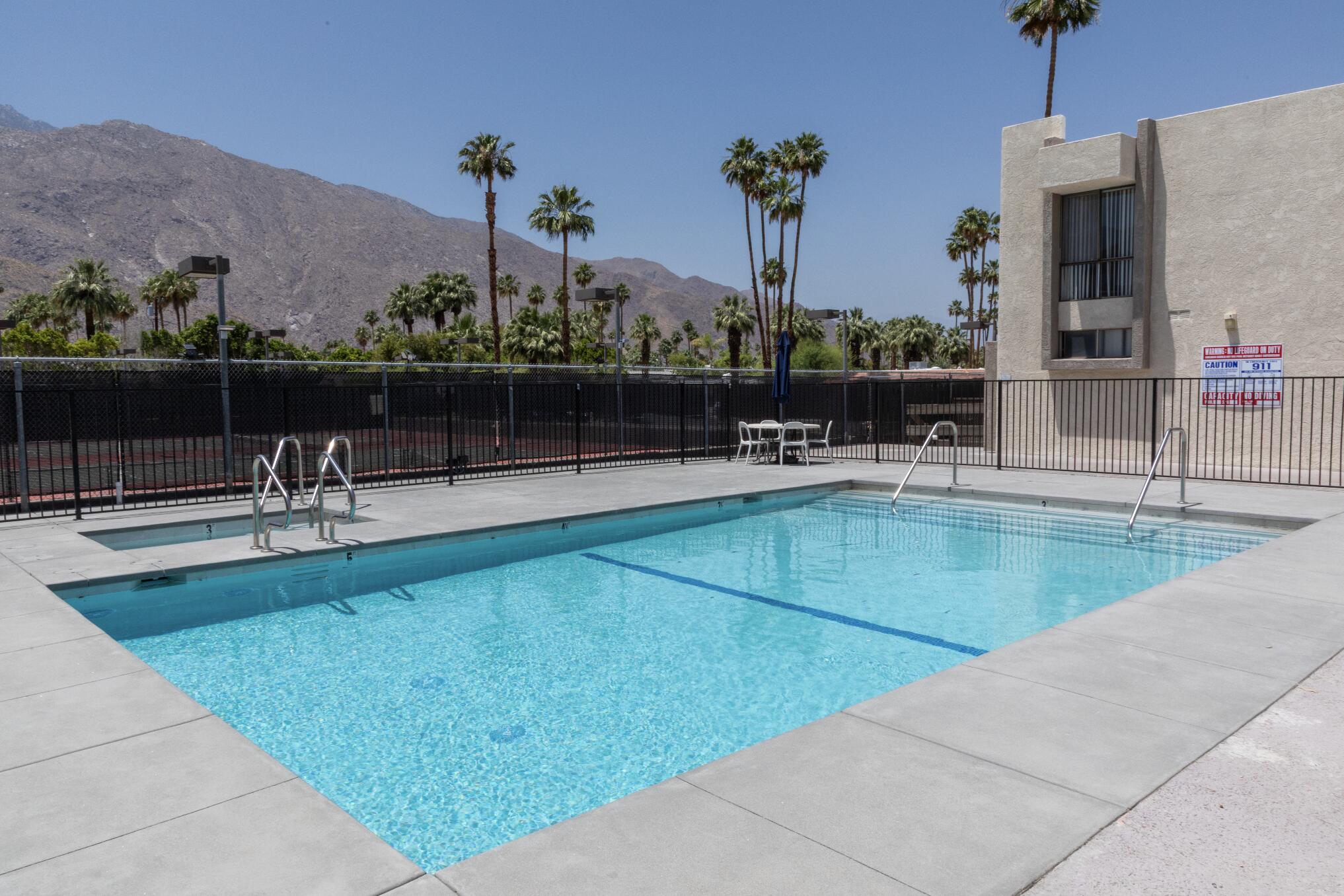 1400 East Palm Canyon Drive, Unit 109 Palm Springs, CA 92264 - Photo 9 of 14 a view of a swimming pool with a patio and a garden