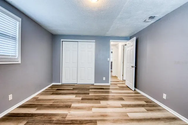 a view of a livingroom with wooden floor and a bathroom