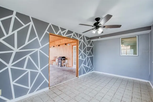 a dinning room with white walls and ceiling fan