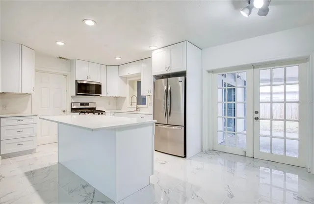 a kitchen with stainless steel appliances a refrigerator sink and microwave