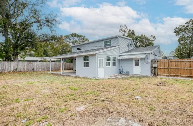 a view of a house with a yard and wooden fence