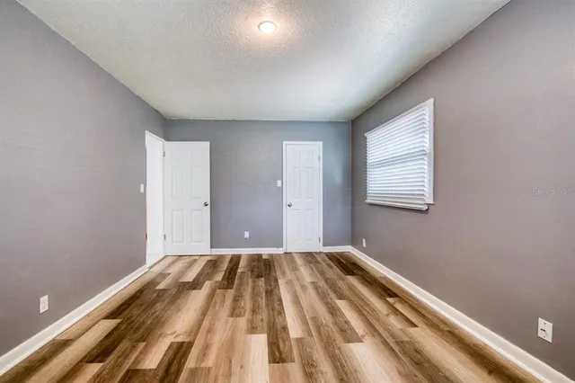 a view of a room with wooden floor and a window