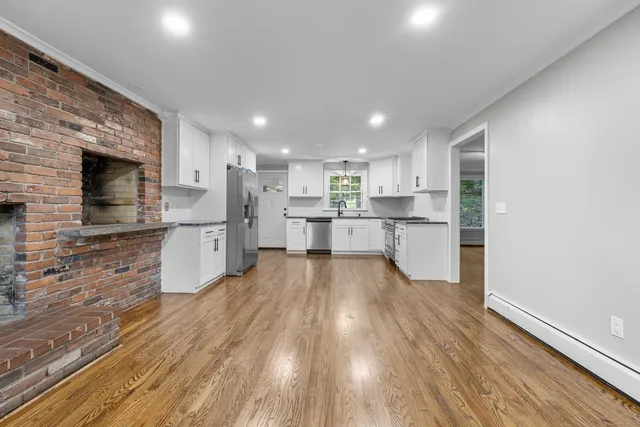 a large kitchen with stainless steel appliances kitchen island a large counter top and a stove top oven