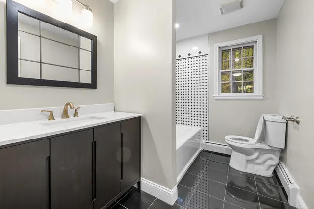 a bathroom with a toilet sink and mirror