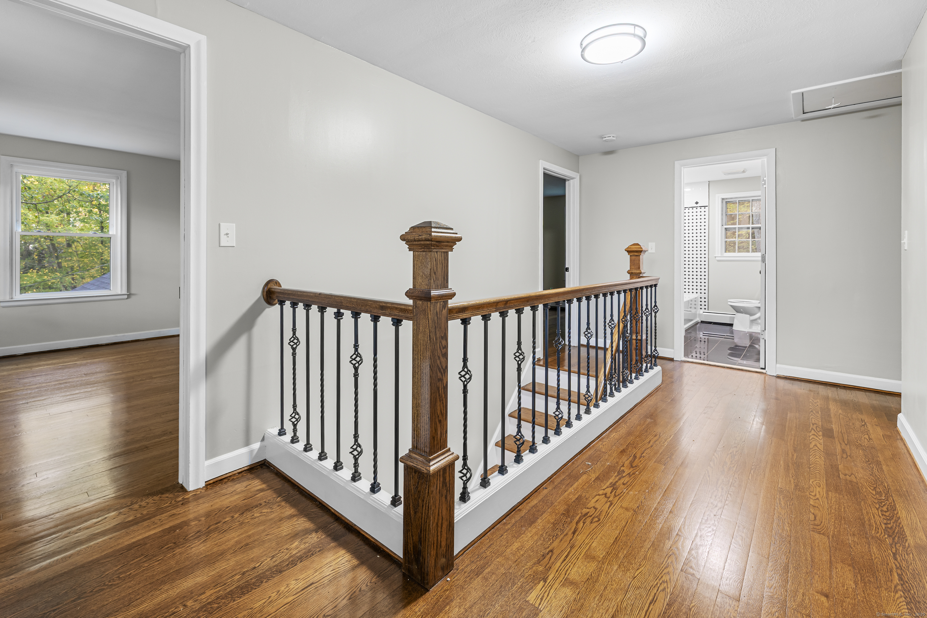545 Simsbury Road Bloomfield, CT 06002 - Photo 30 of 39 a view of a hallway with wooden floor and a bathroom