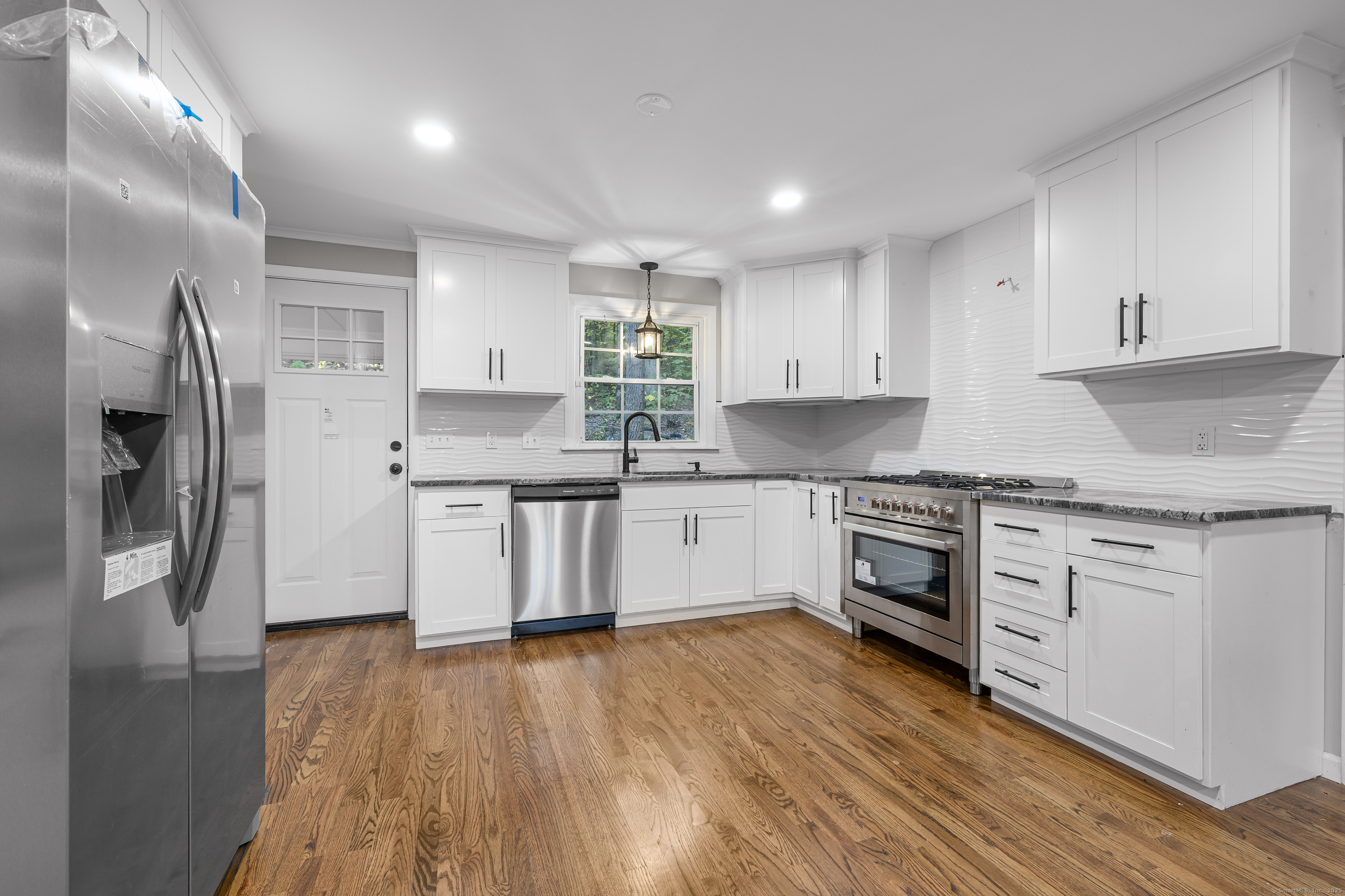 545 Simsbury Road Bloomfield, CT 06002 - Photo 4 of 39 a kitchen with stainless steel appliances granite countertop a stove a sink and a refrigerator