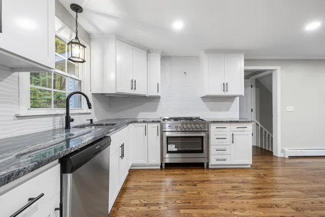 a kitchen with stainless steel appliances granite countertop a stove and a sink