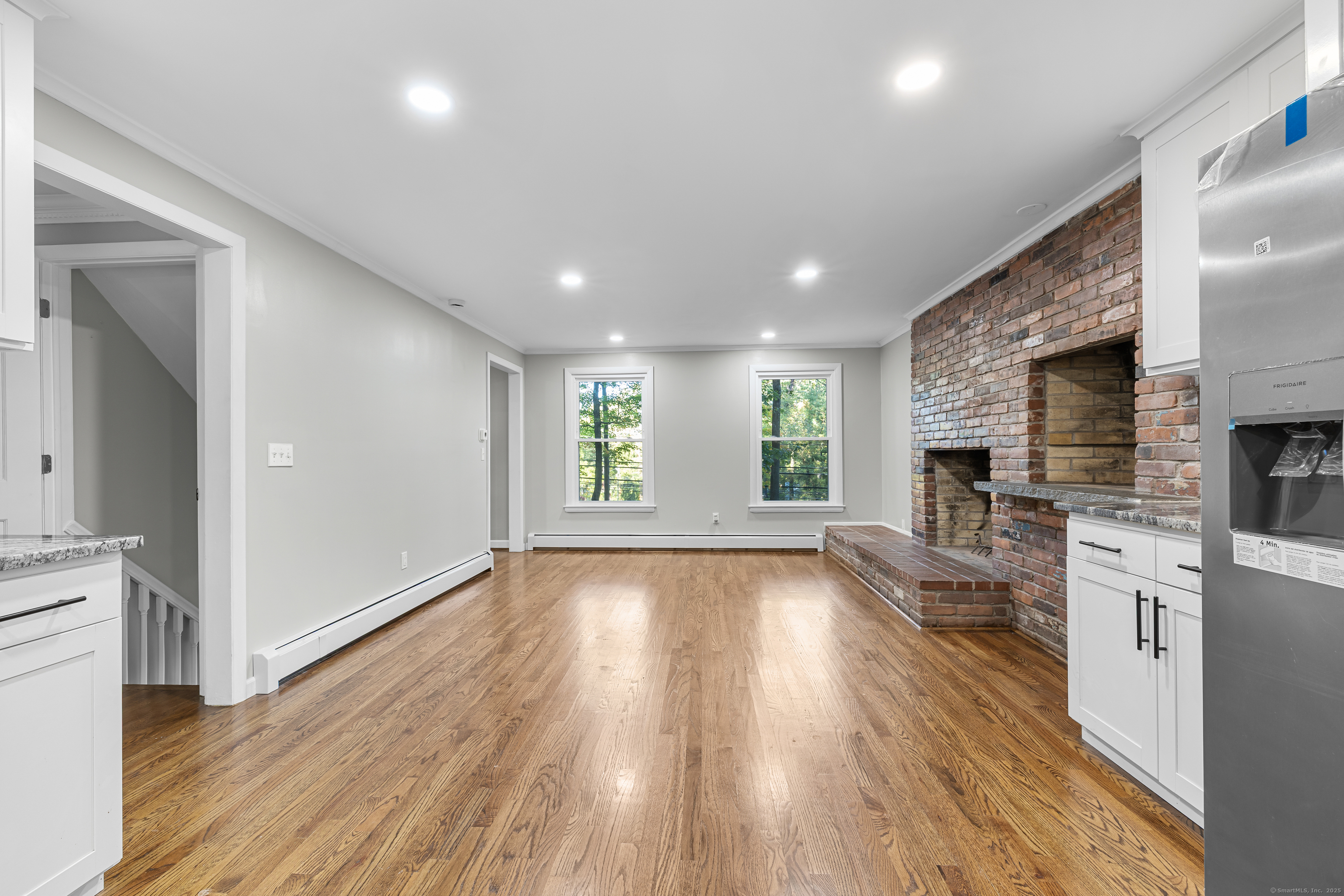545 Simsbury Road Bloomfield, CT 06002 - Photo 6 of 39 an empty room with wooden floor and a kitchen