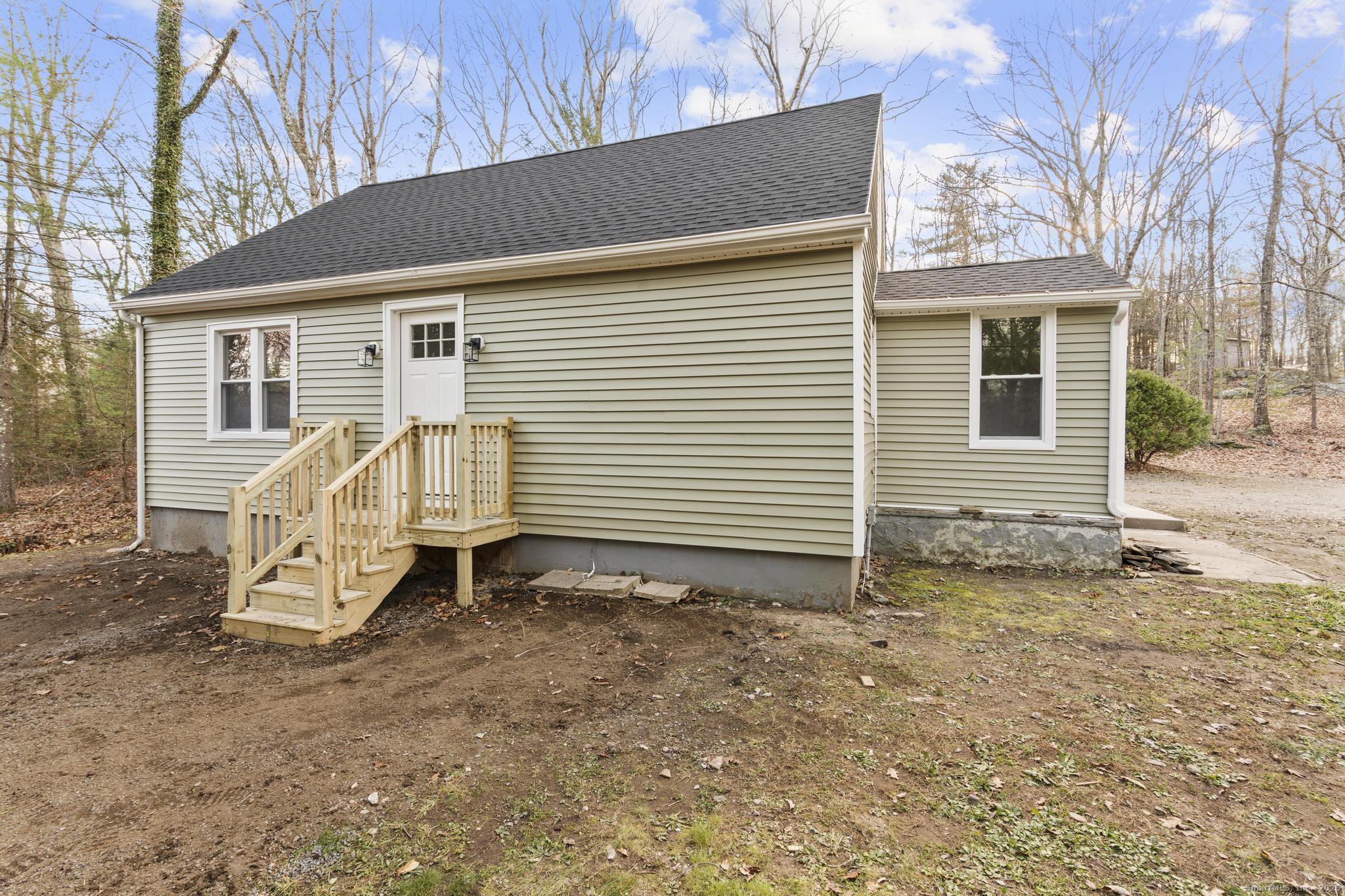 a view of a house with a yard and wooden fence