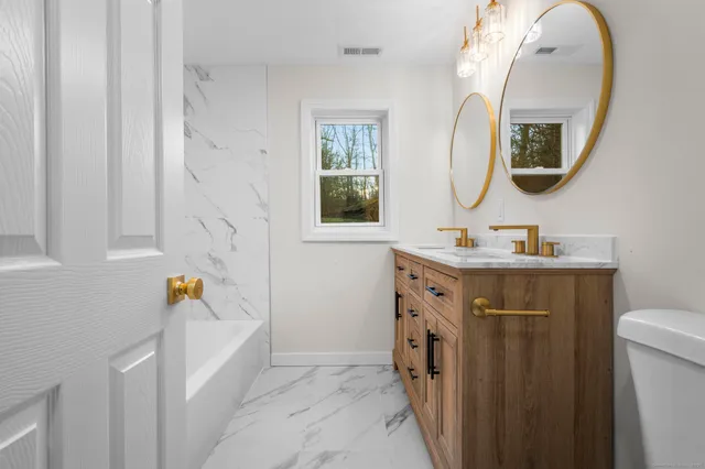 a bathroom with a sink mirror vanity and toilet