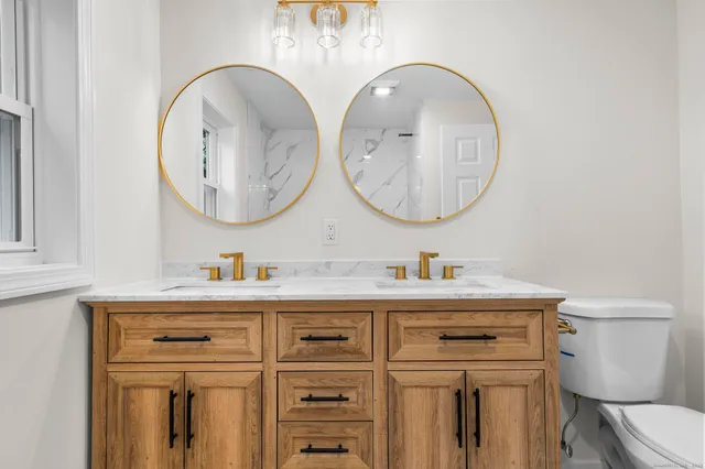 a bathroom with a toilet a sink and a mirror