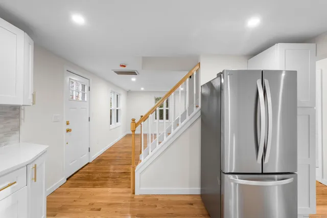 a view of a kitchen with staircase and refrigerator
