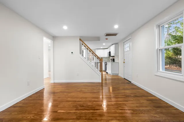 a view of entryway and hall with wooden floor