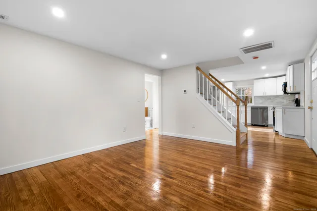 a view of empty room with wooden floor