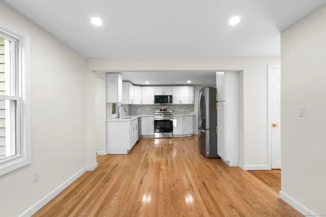 a view of kitchen with wooden floor electronic appliances and window