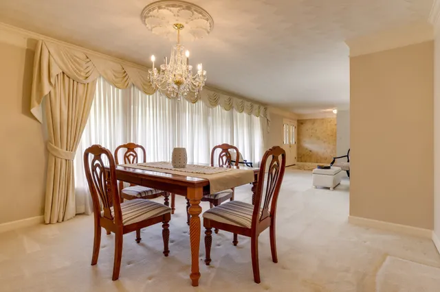 a dining room with furniture a chandelier and a rug