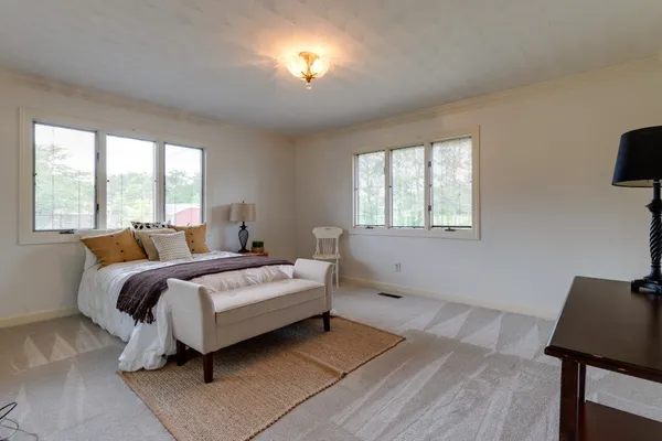 a bedroom with a bed a mirror and a window