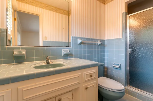 a large white kitchen with a large window and stainless steel appliances