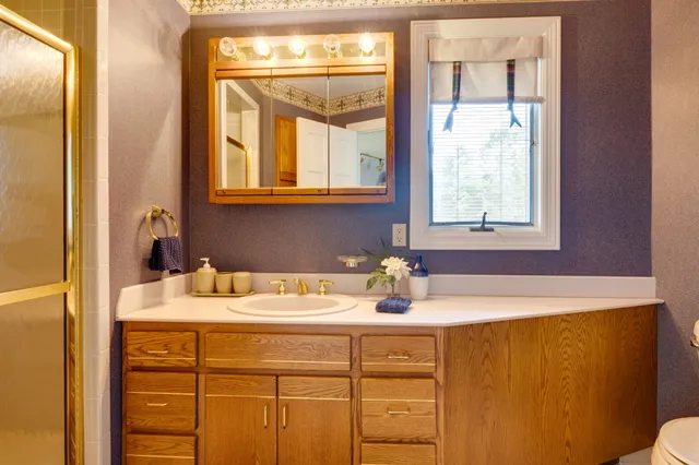 a bathroom with a toilet sink and mirror