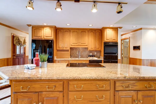 a kitchen with granite countertop a sink and cabinets