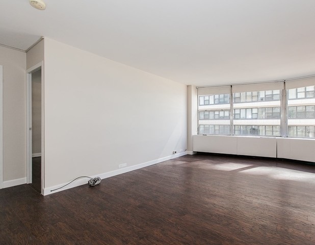 5757 North Sheridan Road, Unit 9C Chicago, IL 60660 - Photo 11 of 25 an empty room with wooden floor and windows