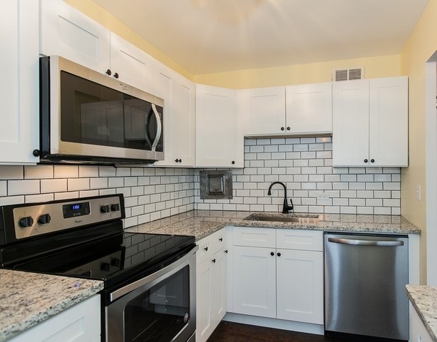 5757 North Sheridan Road, Unit 9C Chicago, IL 60660 - Photo 2 of 25 a kitchen with granite countertop a sink stove and microwave