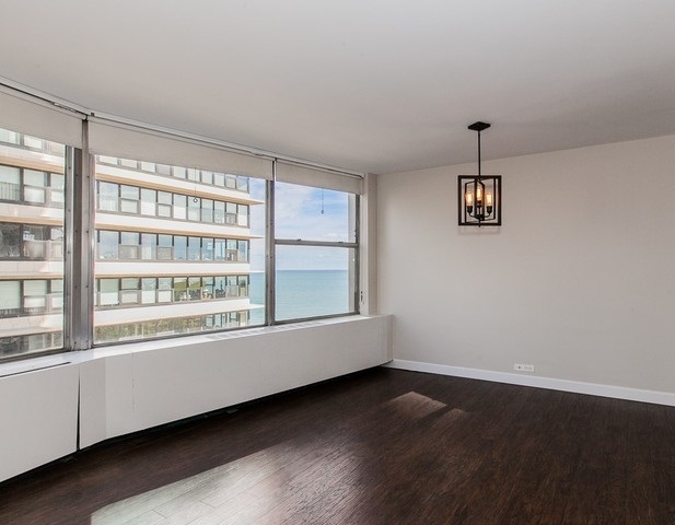 5757 North Sheridan Road, Unit 9C Chicago, IL 60660 - Photo 8 of 25 an empty room with wooden floor and windows