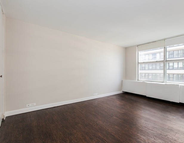5757 North Sheridan Road, Unit 9C Chicago, IL 60660 - Photo 9 of 25 an empty room with wooden floor and windows