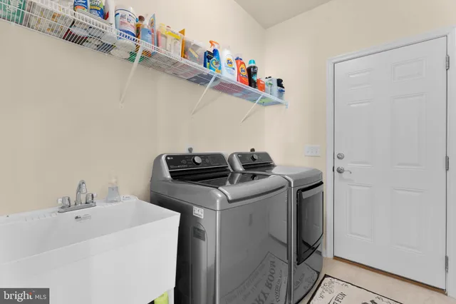 a living room with lots of furniture kitchen view and a table