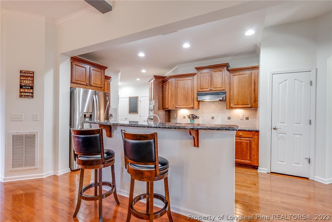 7744 Berry Crest Avenue Raleigh, NC 27617 - Photo 15 of 42 a kitchen with stainless steel appliances granite countertop a refrigerator and a stove top oven