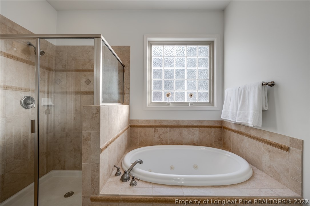 7744 Berry Crest Avenue Raleigh, NC 27617 - Photo 25 of 42 a bathroom with a tub and shower