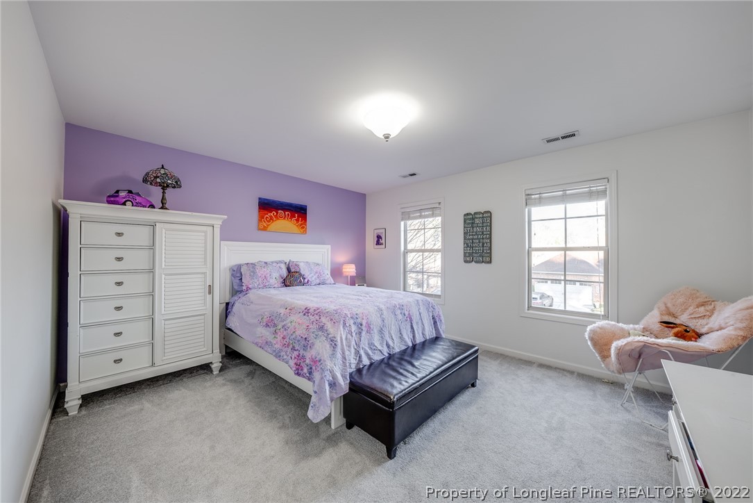 7744 Berry Crest Avenue Raleigh, NC 27617 - Photo 34 of 42 a spacious bedroom with a bed and wooden floor
