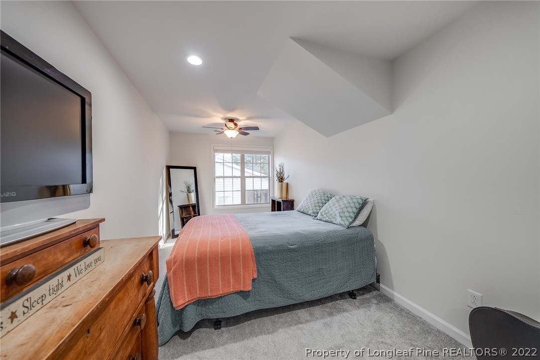 7744 Berry Crest Avenue Raleigh, NC 27617 - Photo 41 of 42 a bedroom with a bed and a flat screen tv