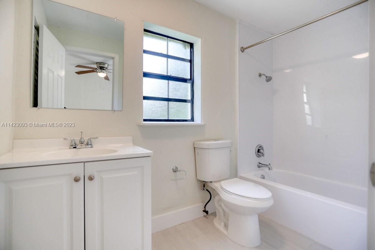 3632 Thomas Avenue Miami, FL 33133 - Photo 12 of 20 a bathroom with a toilet a sink a mirror a bathtub and vanity
