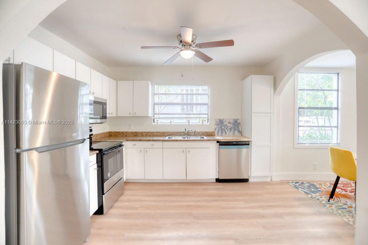 3632 Thomas Avenue Miami, FL 33133 - Photo 5 of 20 a kitchen with stainless steel appliances granite countertop a refrigerator and a stove top oven