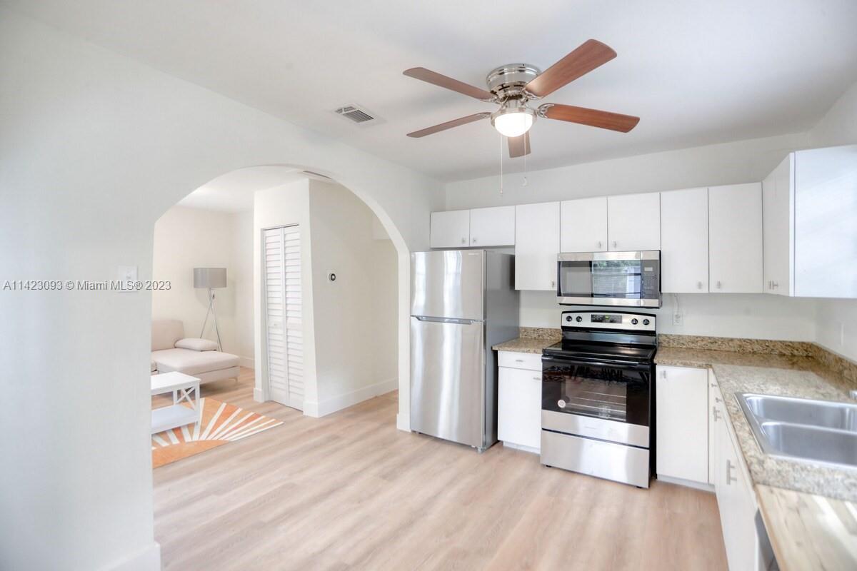 3632 Thomas Avenue Miami, FL 33133 - Photo 6 of 20 a kitchen with stainless steel appliances a stove a refrigerator and a sink