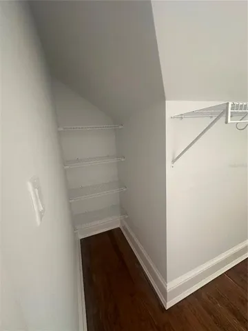 a view of walk in closet with empty racks