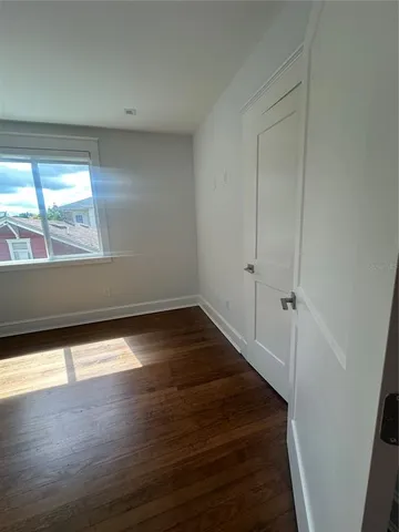 a bathroom with a granite countertop sink a toilet a window and a shower