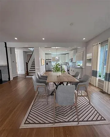 a living room with furniture a wooden floor and next to a window