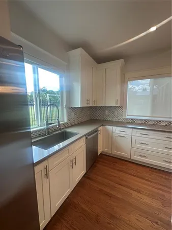a kitchen with granite countertop white cabinets and white appliances