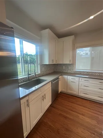 a kitchen with granite countertop white cabinets and white appliances