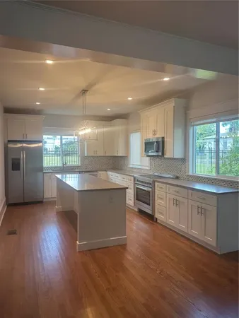 a large kitchen with granite countertop a large counter top stainless steel appliances and cabinets