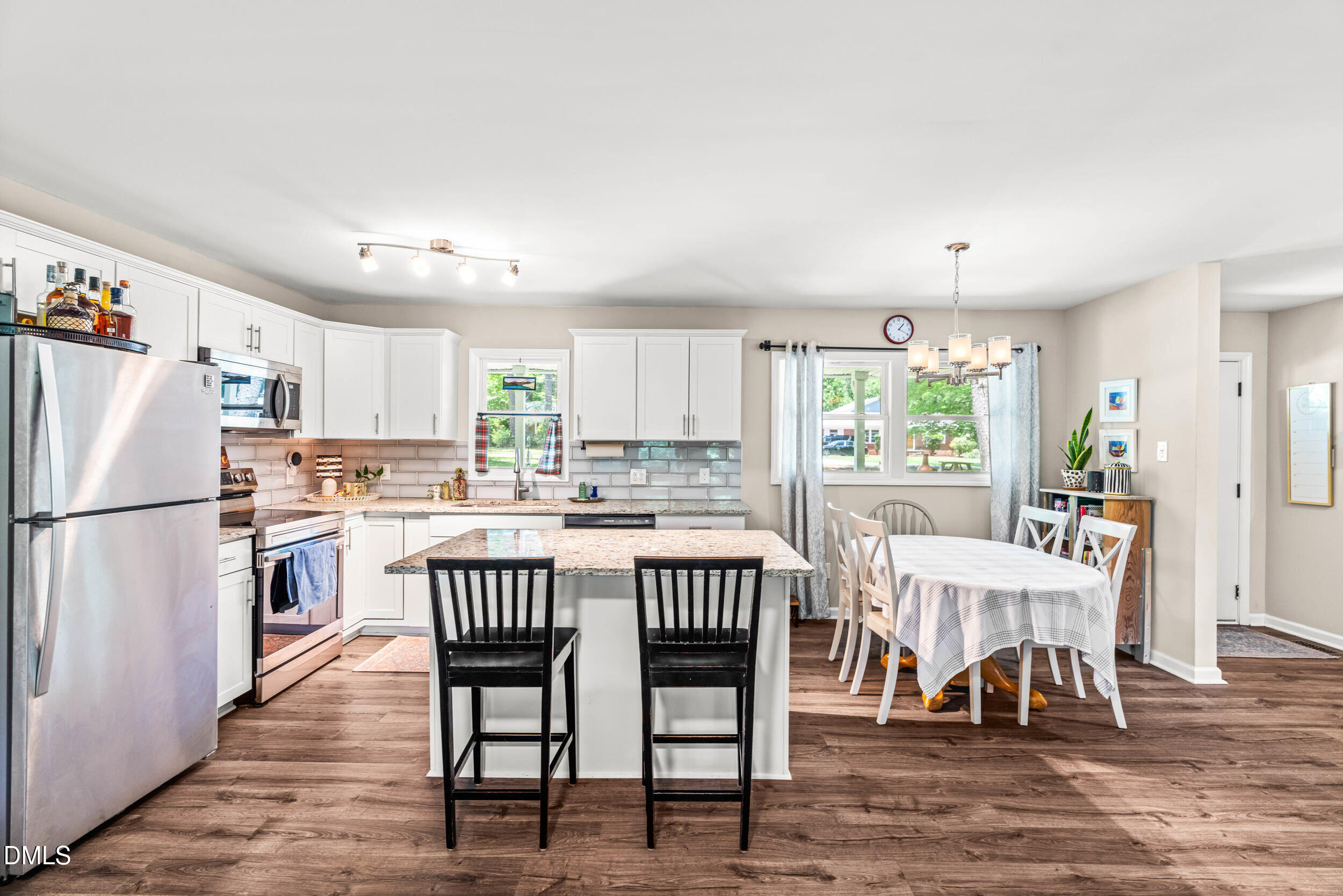 3724 Randell Road Garner, NC 27529 - Photo 10 of 32 a kitchen with stainless steel appliances a white table chairs and a refrigerator