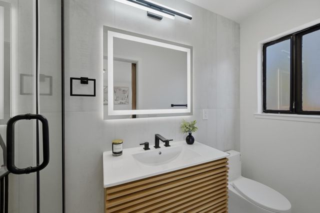 a bathroom with a sink a toilet and shower