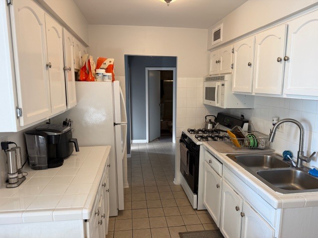 40 North Tower Road, Unit 11K Oak Brook, IL 60523 - Photo 4 of 9 a kitchen with white cabinets and appliances