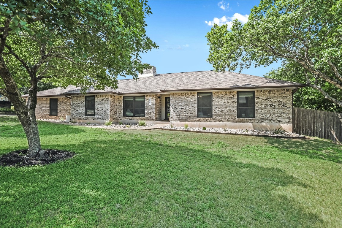 Single story home with brick siding, a chimney, and a shingled roof
